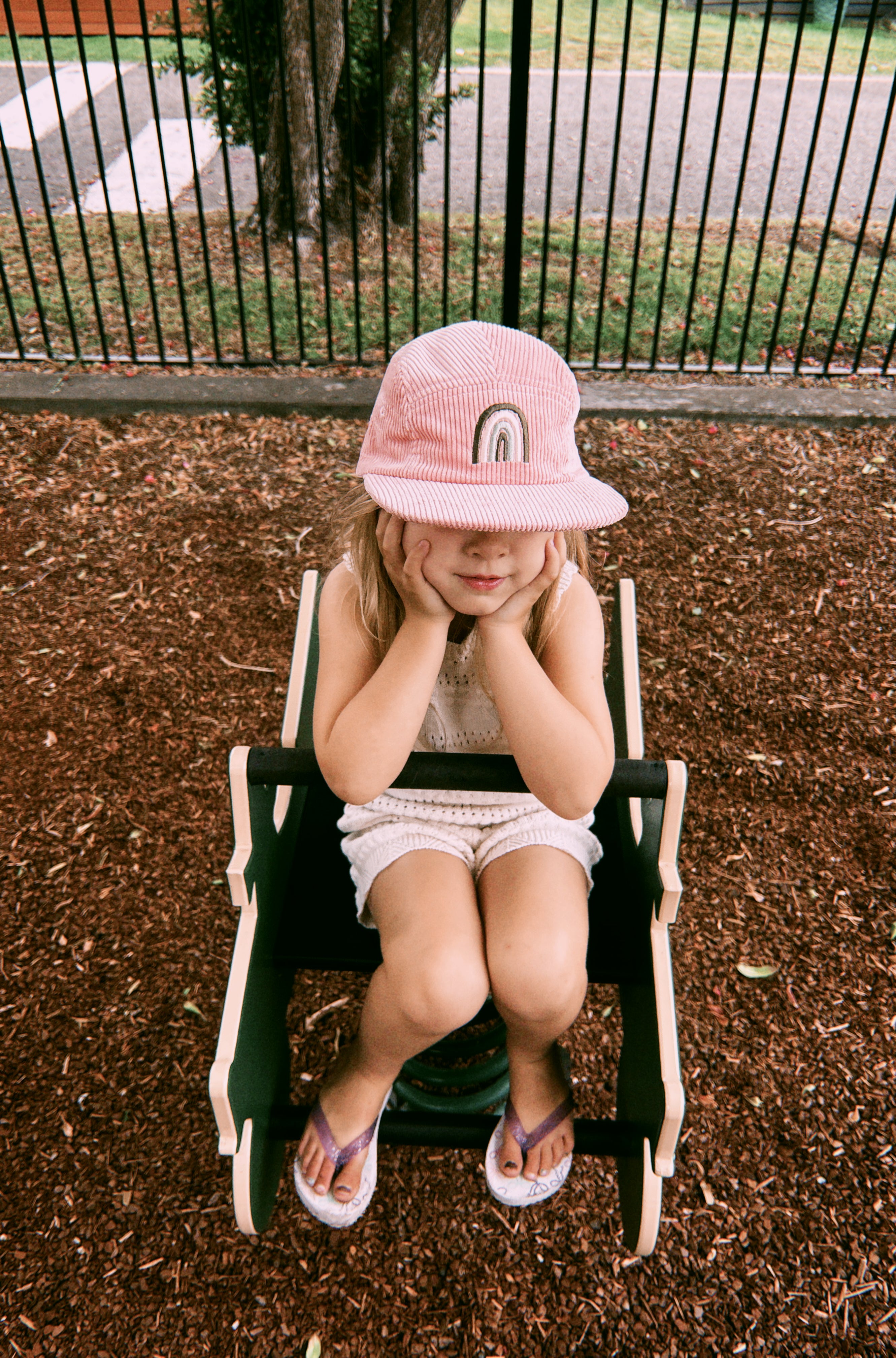 Pink kids corduroy hat with a rainbow design 
