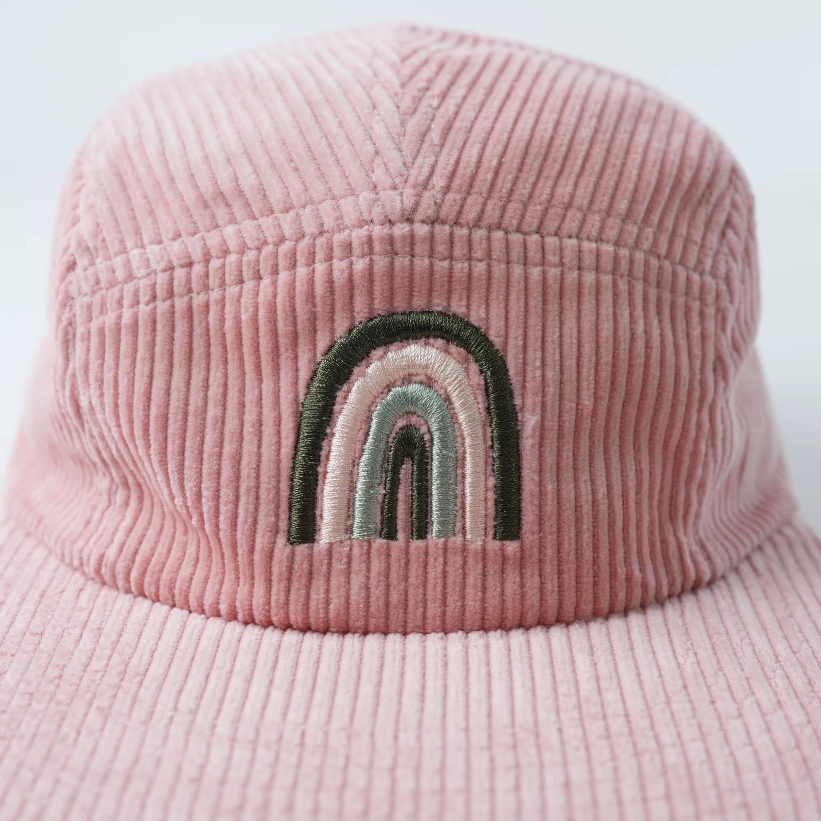 Pink kids corduroy hat with a rainbow design 